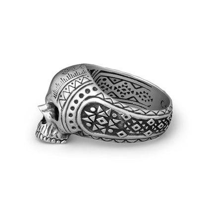 Silver skull ring with intricate patterns on a white background