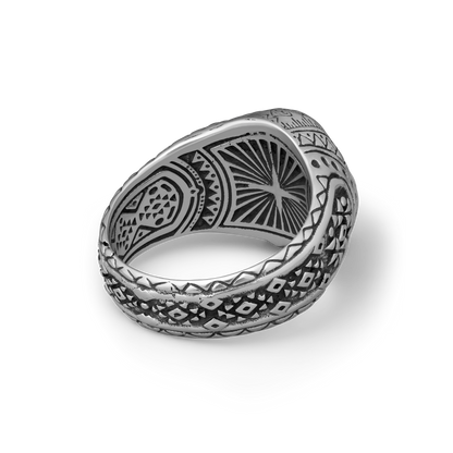 Silver ring with intricate patterns on a white background